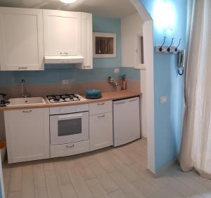 a kitchen with white cabinets and a stove top oven at Maridea - Ponza low cost in Ponza