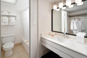 a bathroom with a sink and a toilet and a mirror at Avanti Palms Resort And Conference Center in Orlando