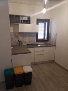a kitchen with a counter and two trash cans at Casa di Magda in Castellammare del Golfo