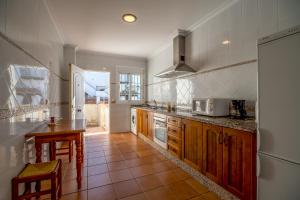 een keuken met houten kasten en een aanrechtblad bij Chalet adosado Atalaya F in Conil de la Frontera