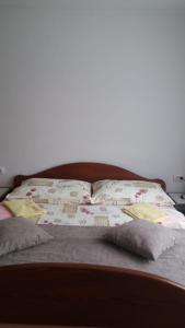 a bed with two pillows and a book on it at Apartment Ankica in Seliste Dreznicko
