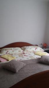 a bed with two pillows on top of it at Apartment Ankica in Seliste Dreznicko