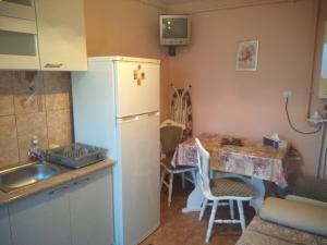 una cucina con frigorifero e tavolo con sedie di Casa Sahar a Turda