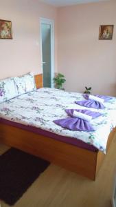 a bed with purple blankets and pillows on it at Casa Sahar in Turda
