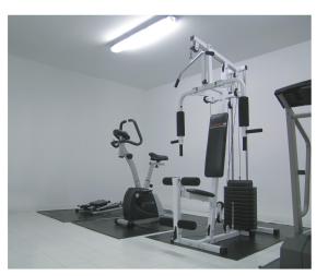 a gym with two treadmills and two exercise bikes at Elegance Hotel in Tres Arroyos