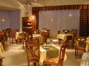 una sala da pranzo con tavoli e sedie con tovaglie gialle di Elegance Hotel a Tres Arroyos