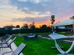 un groupe de chaises et de parasols dans une cour dans l'établissement Agriturismo Quercetelli, à Castiglione del Lago