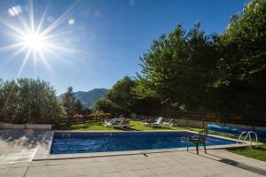 a pool with a chair and the sun in the sky at Apartamentos MultiBaqueira in Baqueira-Beret