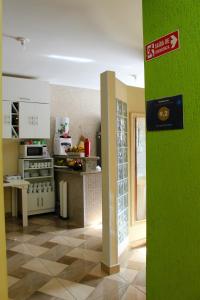 a kitchen with a green wall in a room at Pousada Renascer II in Cachoeira Paulista