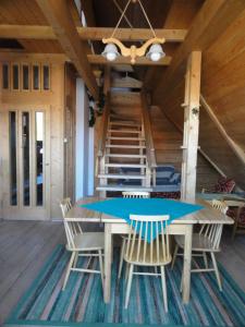 una mesa de madera y sillas en una habitación con escaleras en Apart-Med, en Zakopane