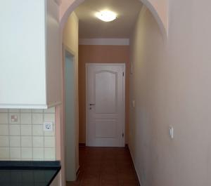 a hallway with a white door and a white tile floor at Ivana apartman 3 in Crikvenica