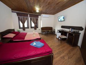 a bedroom with two beds and a desk and a piano at Гурме хаус in Gabrovo