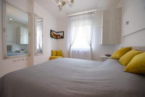 una camera da letto con un grande letto con cuscini gialli di Navigator City Center a Novi Sad
