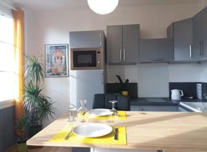 uma cozinha com uma mesa de madeira e um lavatório em Appt 2ème étage sur l’ile de Saumur em Saumur