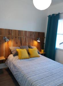um quarto com uma cama grande e almofadas amarelas em Appt 2ème étage sur l’ile de Saumur em Saumur