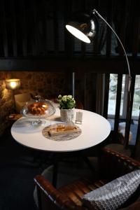 a white table with two plates of food on it at Fragas do Lobo - Casa da Azenha in Castelo Novo