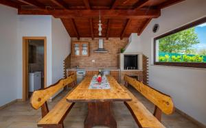 een eetkamer met een houten tafel en banken bij House Smoky with private pool and jacuzzi in Pazin