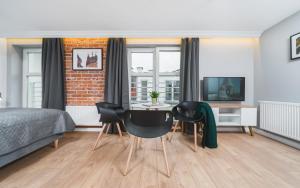 een slaapkamer met een bed, een tafel en stoelen bij Barbakan Residence Old Town in Krakau