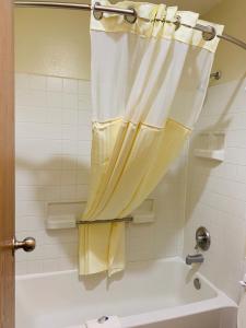 cortina de ducha en el baño con bañera en Luxury Inn, en Albuquerque
