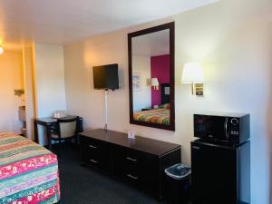 a hotel room with a bed and a mirror at Luxury Inn in Albuquerque