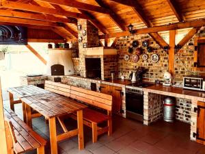 a large kitchen with a wooden table and a stove at Bence Apartman in Tiszabábolna