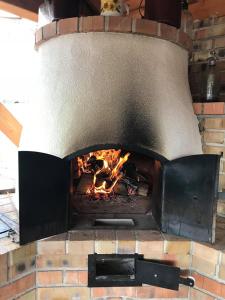 a brick oven with a fire in it at Bence Apartman in Tiszabábolna