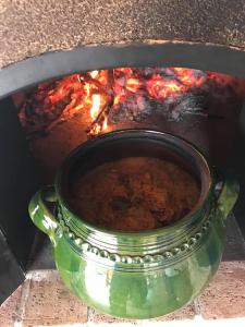 a pot of food cooking in a fire oven at Bence Apartman in Tiszabábolna