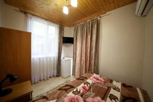 Un dormitorio con una cama con flores rosas. en Guest House on Chernomorskaya Ulitsa, en Anapa