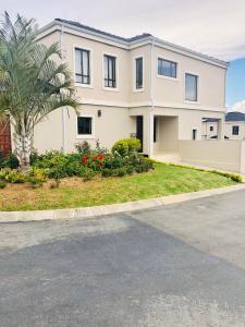 a large white house with a palm tree and a street at Cluster 59 Issa in Midrand