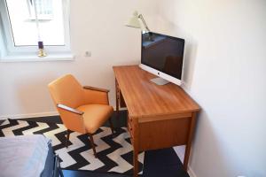 Habitación con escritorio, TV y silla. en Maison Cyriax, en Harzgerode