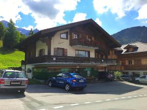 a blue car parked in front of a building at Chalet Floriana in Les Diablerets