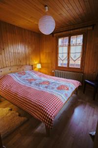 a bedroom with a bed with a red and white blanket at Chalet Floriana in Les Diablerets