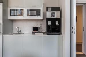 a kitchen with white cabinets and a sink at Livgrenadjärmässen Hotell-Fest-Konferens in Linköping
