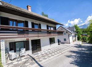 a house with a table and chairs outside of it at Apartmaji Baron in Bled