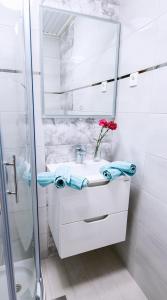 Baño blanco con lavabo y espejo en Apartmaji Baron, en Bled