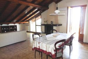 ein Esszimmer mit einem Tisch und Stühlen in einem Zimmer in der Unterkunft Mansarda sul mare dei Ciclopi in Acitrezza