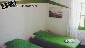 a bedroom with two green beds in a room at h2oholidays for you in Capbreton