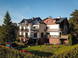 a large house with a yard with a playground at Willa Zacisze - Ostrowo - Komfortowe Apartamenty i Pokoje w cichej okolicy - Oaza spokoju in Ostrowo