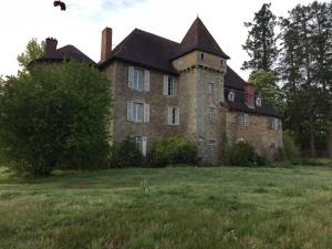 een oud bakstenen gebouw met een schoorsteen op een veld bij Chateau de Grand Bonnefont in Limoges