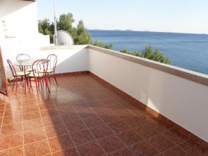 a balcony with a table and chairs and the ocean at Apartments Marija - 30m from the beach in Murter