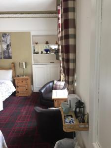 a bedroom with a bed and a couch and a chair at Tanglin Guest House in Oban