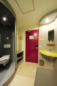 a bathroom with a red door and a sink at POP! Hotel Kuta Beach in Kuta