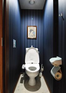 a bathroom with a toilet and a picture on the wall at Hostel Hana An in Tokyo