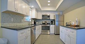 eine Küche mit weißen Schränken und Küchengeräten aus Edelstahl in der Unterkunft Crescent Beach 1011 #3 in Sarasota