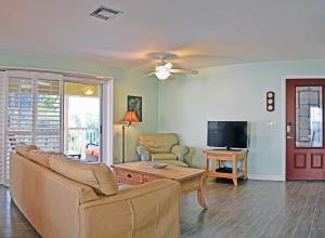 ein Wohnzimmer mit einem Sofa und einem TV in der Unterkunft Crescent Beach 1015 #4 in Sarasota