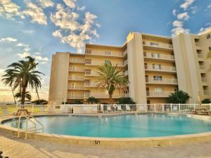 a pool in front of a hotel with palm trees at Siesta Key Beach 5830 #T34 in Siesta Key