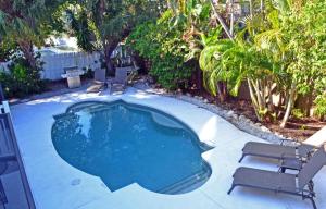 a small swimming pool with two chairs and a table at Crescent Beach 1011 #3 in Sarasota