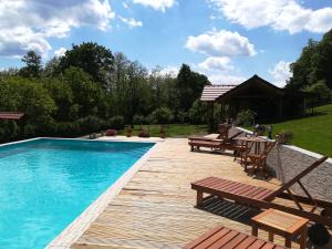 una piscina con bancos y una terraza de madera en Grebengradska Medna Hiža en Donje Makojišće