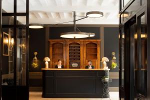 two people sitting at a bar in a restaurant at Hôtel Longemalle in Geneva