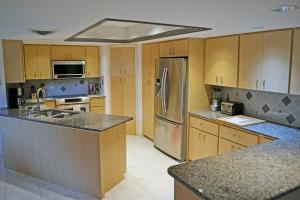 uma cozinha com armários de madeira e um frigorífico de aço inoxidável em Shell Beach - The Treehouse 210 em Sarasota